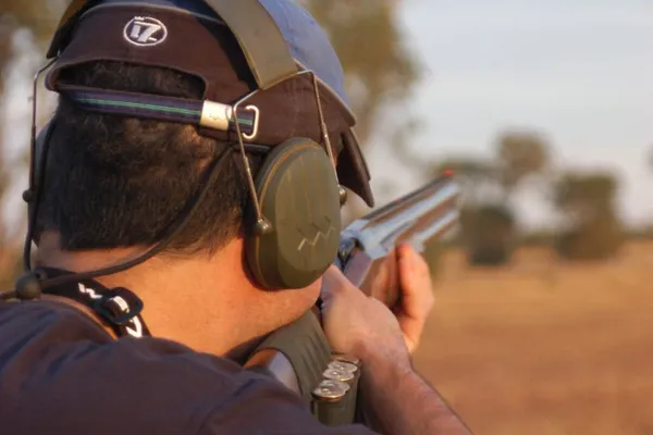 Shotgun shooter in silhouette against the Pilbara bush.